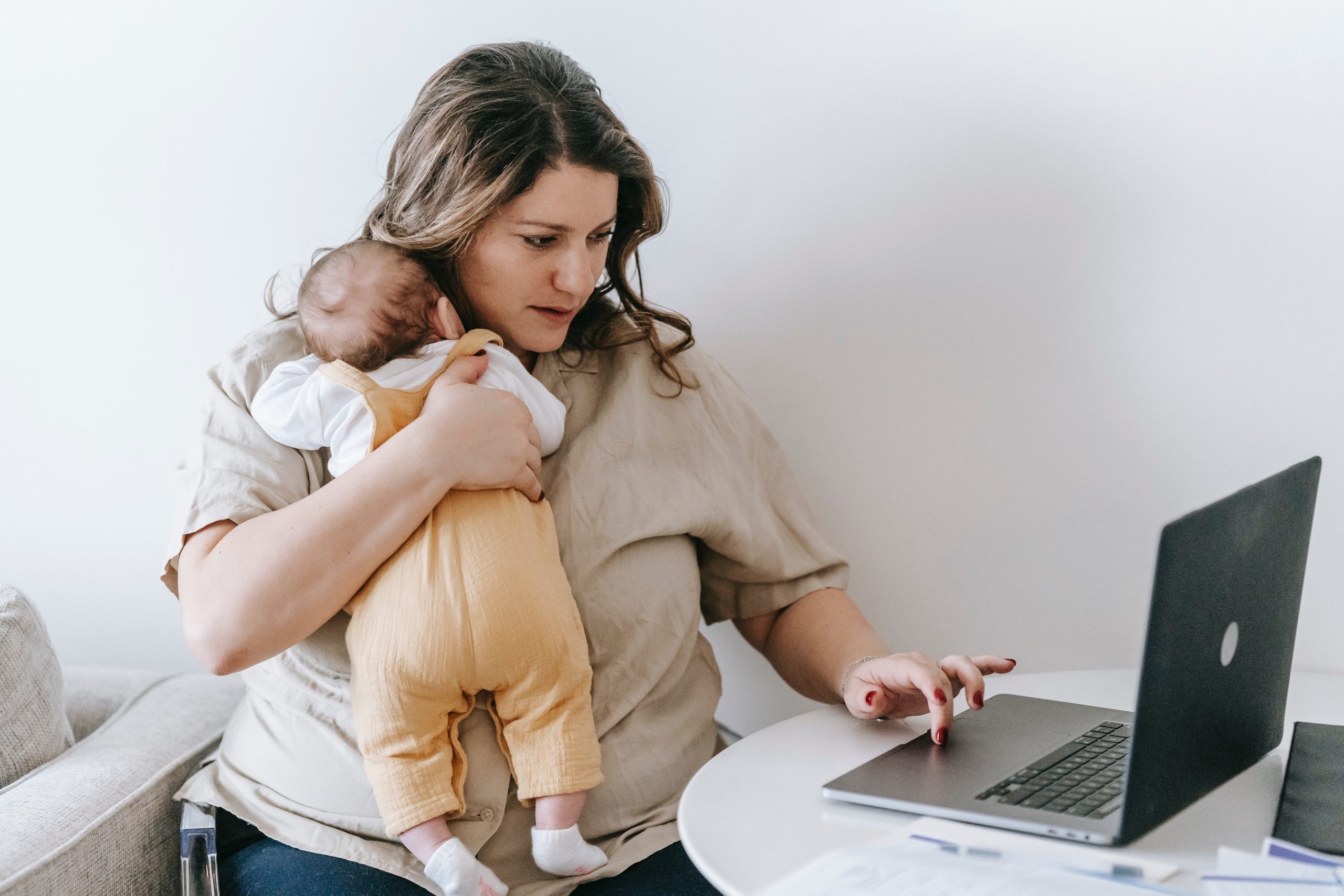 woman holding baby while working from home