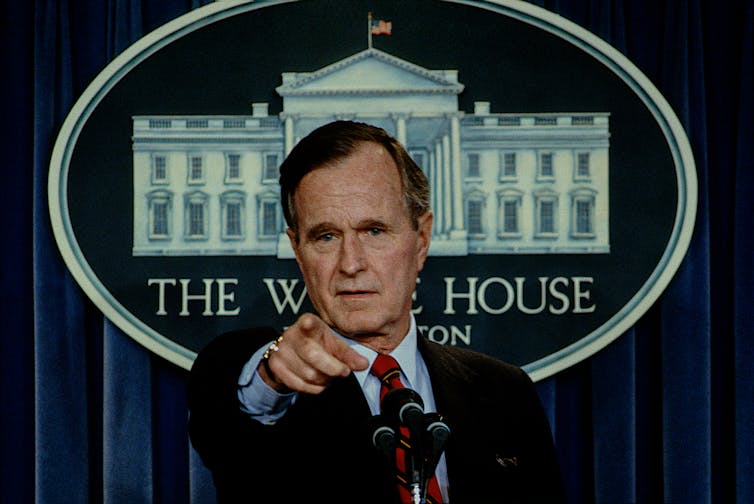 President George H.W. Bush points to a reporter while answering questions during a press briefing in the White House Press briefing room.
