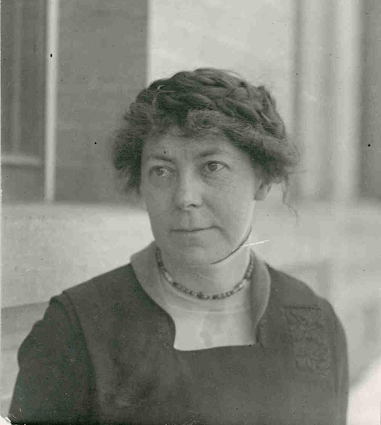 A sepia-toned photograph of Inga Allison, a white woman in dark clothes with her hair pulled back.