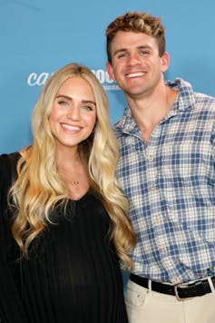 Young, blonde couple smiling and posing.