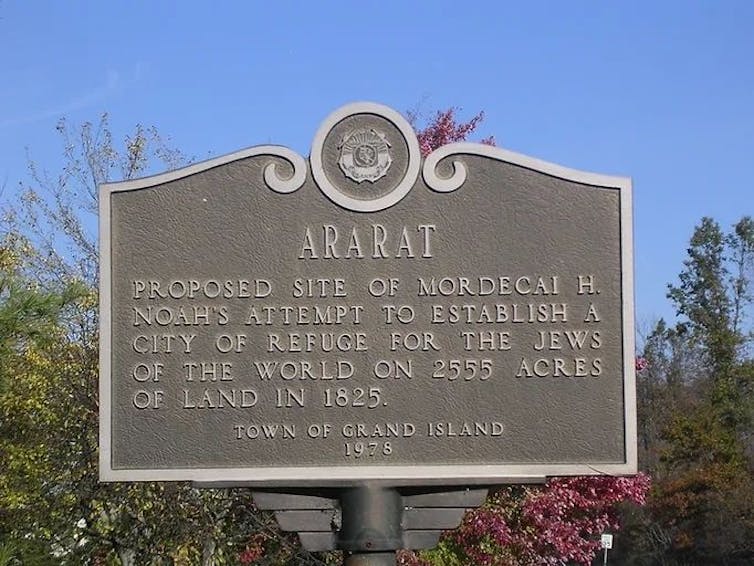 A bronze-colored historical plaque outside that says 'Ararat' at the top