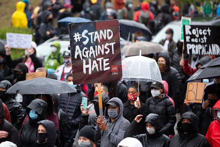 A protest rally. One sign reads: Stand Against Hate