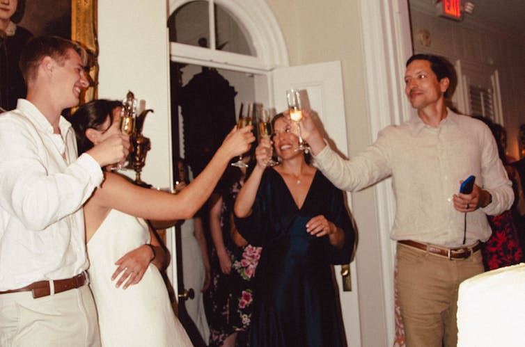 bride and groom cheers their glasses with guests