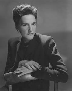 Young woman with short hair posing for a photograph while seated.