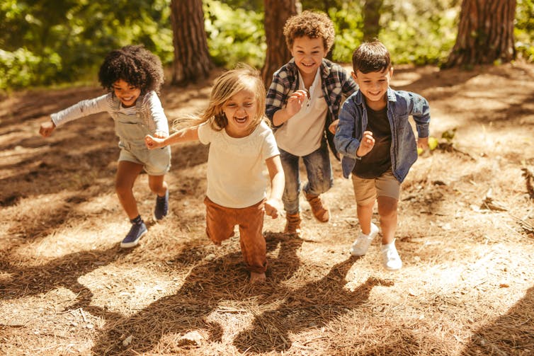 A group of children running outdoors.