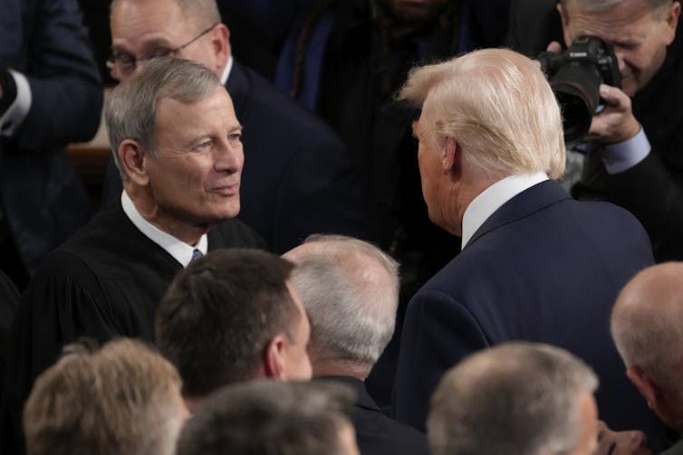 Two men speaking in a crowd.