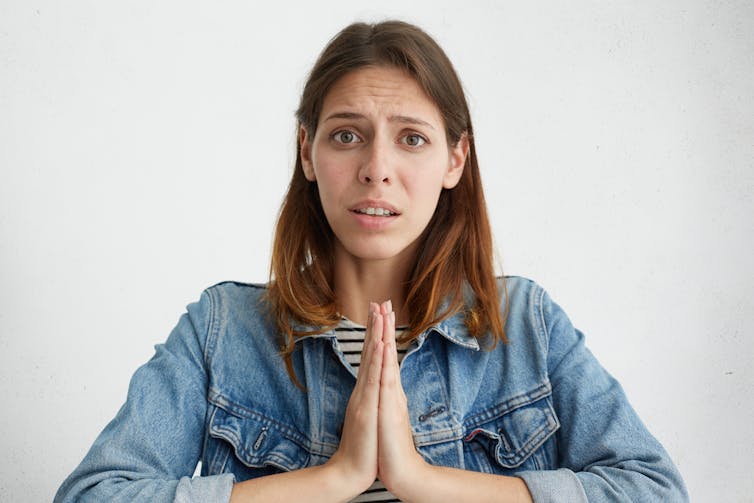 Woman looks at camera with regretful expression