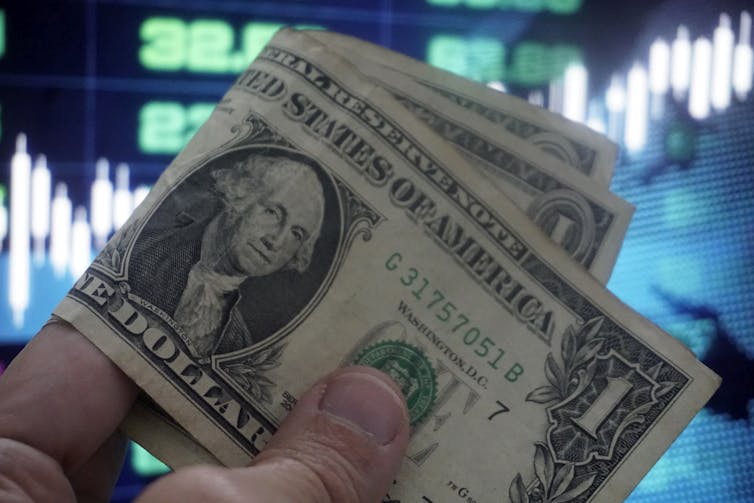 A person holds American dollars.