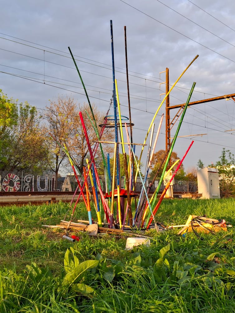 A colourful art installation sprouts from the grass near a railway line in Melbourne.