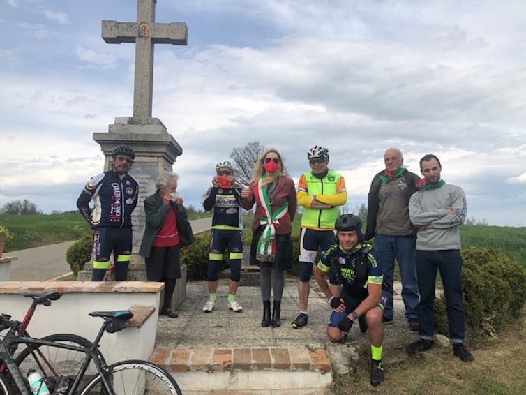 A group of cyclists standing in front of a monument.