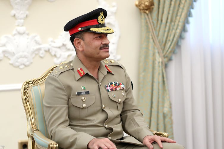 A man in a military uniform is seated.
