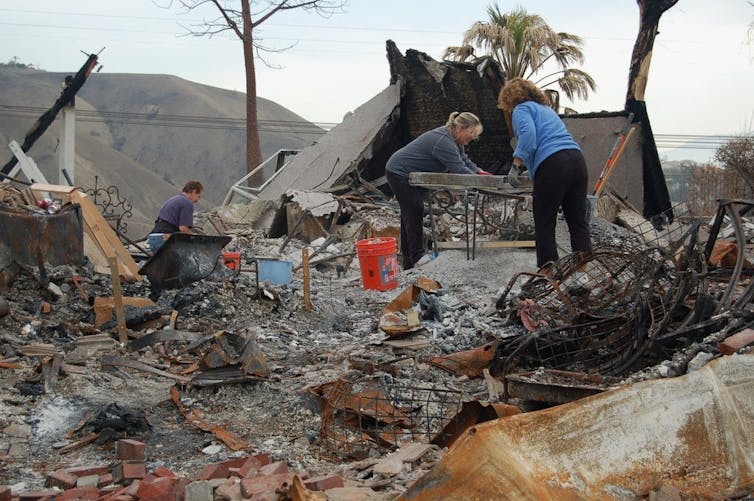 People sort debris after a wildfire