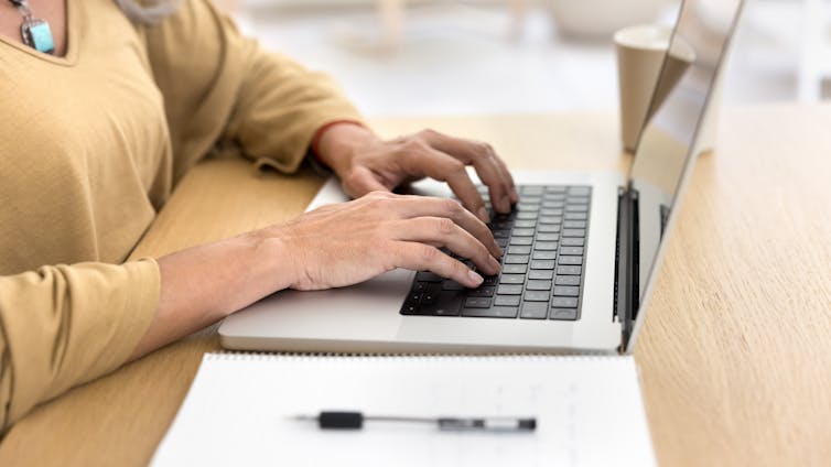 Close up of woman's hands using laptop