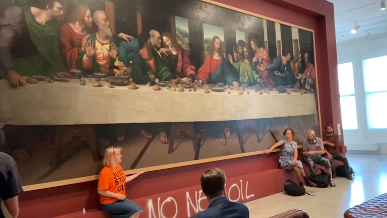 Just Stop Oil protestors with hands glued to the frame of da Vinci's The Last Supper.