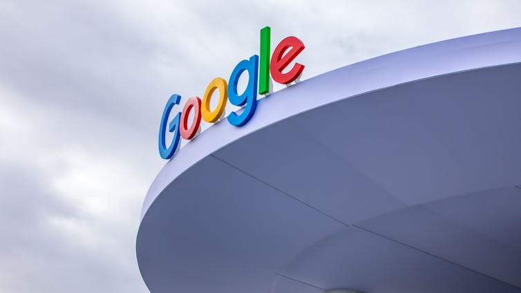 A blue, red, yellow and green Google sign on a building roof.