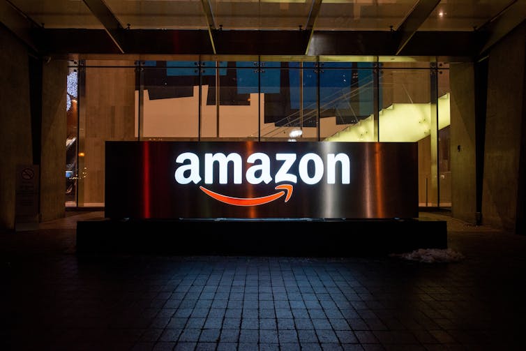 A large Amazon sign outside a glass building.